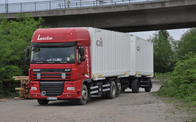 Service Ein Lkw mit Anhänger und zwei aufgesetzten AXIS-Wechselbrücken unter einer Brücke